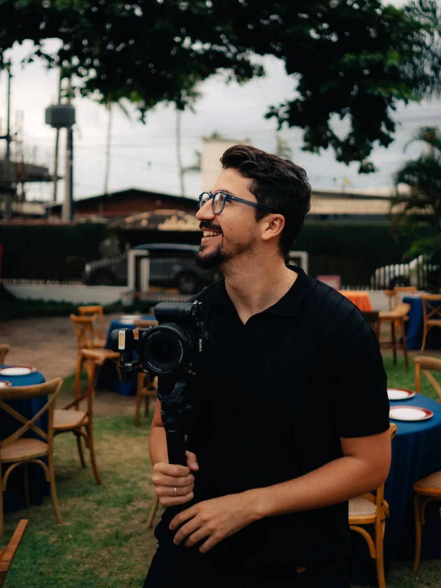Matheus Torres sorrindo com a câmera no gimbal durante uma gravação